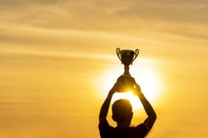 Winner win holding golden champion trophy cup prize. Silhouette best award victory trophy for professional champion challenge team holding gold sport trophy cup over head. Win-Win sport team concept